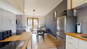 a kitchen and dining room with a table and a refrigerator at Apartament Fibra Flat White in Rybnik
