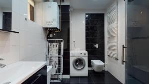 a bathroom with a washing machine and a toilet at Apartament Fibra Flat White in Rybnik +11 photos