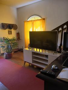 a living room with a large flat screen tv at Pousada Clave de Sol in Conservatória