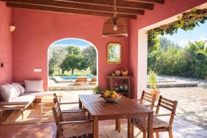 an outdoor living room with a table and a couch at Villa Es Puig, piscina y vistas a la montaña in Santa Margalida +49 photos