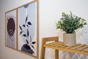a plant sitting on a wooden bench next to a picture at Quartier VierGlück in Marl