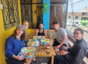 a group of people sitting around a table eating food at Urcia Surf House in Huanchaco +32 photos