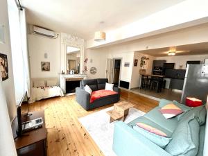a living room with a blue couch and a table at Louisa - Spacieux en Plein centre - Places gratuites - 1er étage in Auch
