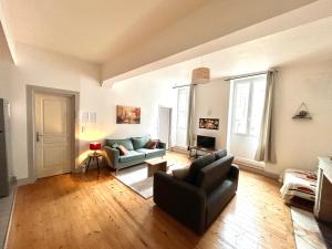 a living room with a couch and a chair at Louisa - Spacieux en Plein centre - Places gratuites - 1er étage in Auch