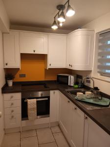 a kitchen with white cabinets and a stove top oven at The Studio in Windermere