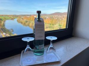 a bottle of wine and two wine glasses on a window at Hotel Brückentor in Rinteln