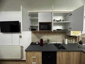 a kitchen with white cabinets and a black counter top at Central Studio in Piteşti