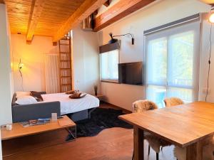 a bedroom with a bed and a table with chairs at Maison Poluc - Maison Monte Rosa in Champoluc