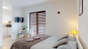 a bedroom with a bed and a table and a kitchen at Studio Fibra Macchiato in Rybnik