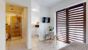 a bedroom with a table and chairs and a bathroom at Studio Fibra Macchiato in Rybnik