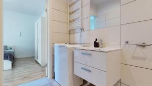 a white bathroom with a sink and a refrigerator at Studio Fibra Macchiato in Rybnik +26 photos