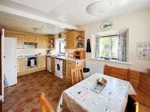 a kitchen with a table and a table and chairs at Coastguard Cottage in Downderry