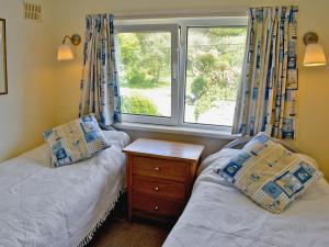 a bedroom with two twin beds and a window at Coastguard Cottage in Downderry +8 photos
