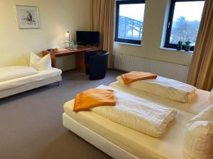 a hotel room with two beds and a desk at Hotel Brückentor in Rinteln