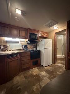 a kitchen with wooden cabinets and a white refrigerator at Rustic cozy couples summer stay in Little Current