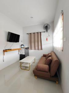 a living room with a couch and a tv at Chiang Khan Dwelling in Chiang Khan
