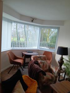 a living room with a couch and chairs and windows at The Studio in Windermere