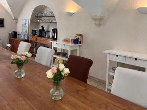 a dining room with a table with vases of flowers on it at Le Moulin de Montségur in Montségur-sur-Lauzon