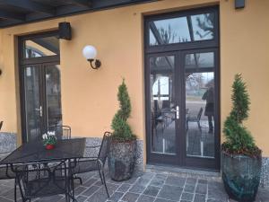 a patio with a table and chairs and windows at Hotel Agnello in Taino