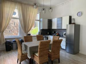 a kitchen with a table with chairs and a refrigerator at Das MONTI - Superior in Stendal
