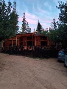 a wooden cabin with a fence in front of it at Casa Hostal Familiar Espacio SaTaNaMa in El Torreón