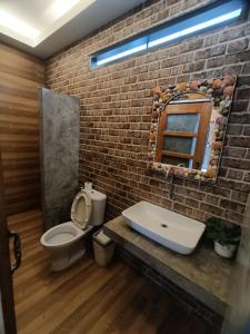 a bathroom with a white toilet and a brick wall at เสม็ดทาวน์ Samed Town in Ko Samed +25 photos