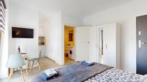 a bedroom with a bed and a table and a kitchen at Studio Fibra Barista in Rybnik