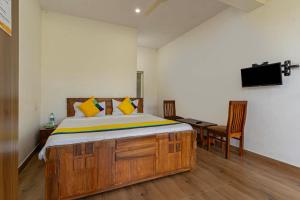a bedroom with a bed and a desk and a television at Itsy Hotels Jammabane Cottage, 5 Minutes To Mountain View Coffee Plantation in Madikeri +24 photos