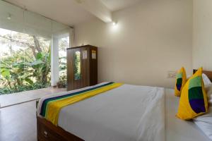 a bedroom with a bed and a large window at Itsy Hotels Jammabane Cottage, 5 Minutes To Mountain View Coffee Plantation in Madikeri