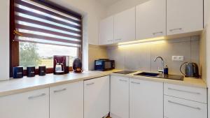 a kitchen with white cabinets and a window at Studio Fibra Barista in Rybnik
