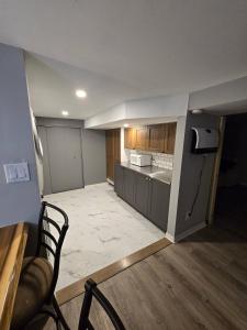 an empty kitchen with a chair in a room at Cozy East Hill 2026 in Belleville +9 photos