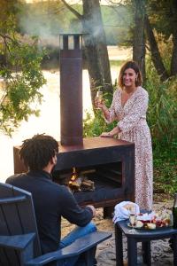 a woman holding a glass of wine in front of a fireplace at Nids des Marais in Ciney