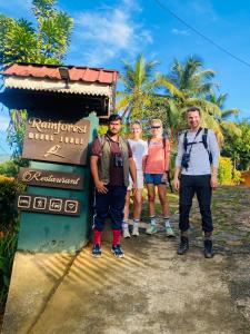 a group of people standing in front of a sign at Rainforest Mount Lodge in Deniyaya