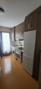 a kitchen with a white refrigerator and a dishwasher at Plaza de la Cruz, 2 in Cazalegas