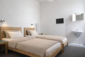two beds in a hotel room with a sink at Villa Amarone in Mannheim