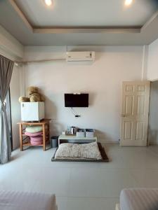 a living room with a television and a door at เสม็ดทาวน์ Samed Town in Ko Samed