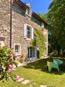 a stone house with a blue bench in the yard at Le Moulin de Montségur in Montségur-sur-Lauzon