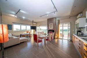 a kitchen and living room with a table and chairs at Villa Sorina Kefalonia in Svoronata