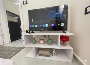a tv on a white shelf in a living room at Younis chalet in Dahab