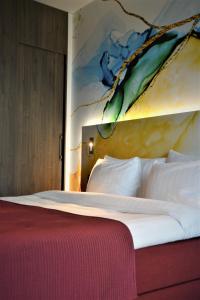 a bedroom with a bed with a painting on the wall at ProfilHotels Halmstad Plaza in Halmstad