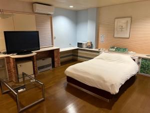 a bedroom with a bed and a flat screen tv at adult only ホテルシャルム in Itoigawa