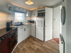 a kitchen with white cabinets and a refrigerator at Emily's Van in Skegness