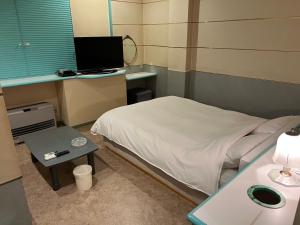 a small room with a bed and a desk with a computer at adult only ホテルシャルム in Itoigawa +10 photos