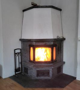 a stone fireplace with a fire in it at Villa Mutkala in Kittilä