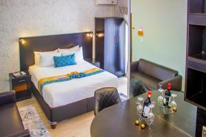 a hotel room with a bed and a table and chairs at Scenery Maqalika Guesthouse in Maseru