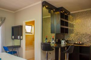 a kitchen with a table and chairs in a room at Scenery Maqalika Guesthouse in Maseru