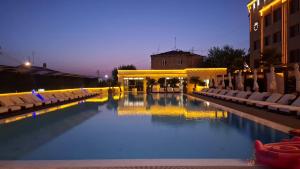 a large swimming pool with chairs and a building at Venice Hotel Complex in Yerevan
