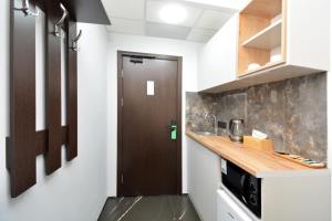 a kitchen with a brown door in a room at Апарт-отель ЛЕВЕЛ Ереван, Ханджян 47 in Yerevan +39 photos