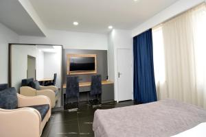 a hotel room with a bed and a desk and a mirror at Апарт-отель ЛЕВЕЛ Ереван, Ханджян 47 in Yerevan