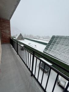 a balcony with snow on the roof of a building at Marhaba Villa in Borjomi